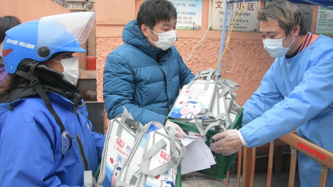 领到牛奶后隔空比心，被隔离市民营养有保障——光明乳业全力保障牛奶供应，守护市民营养健康